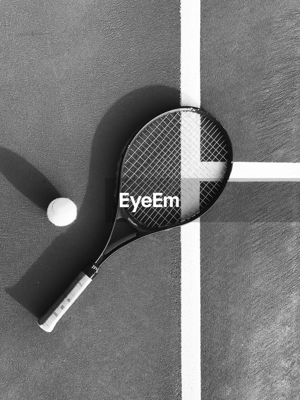 High angle view of racket with tennis ball on court