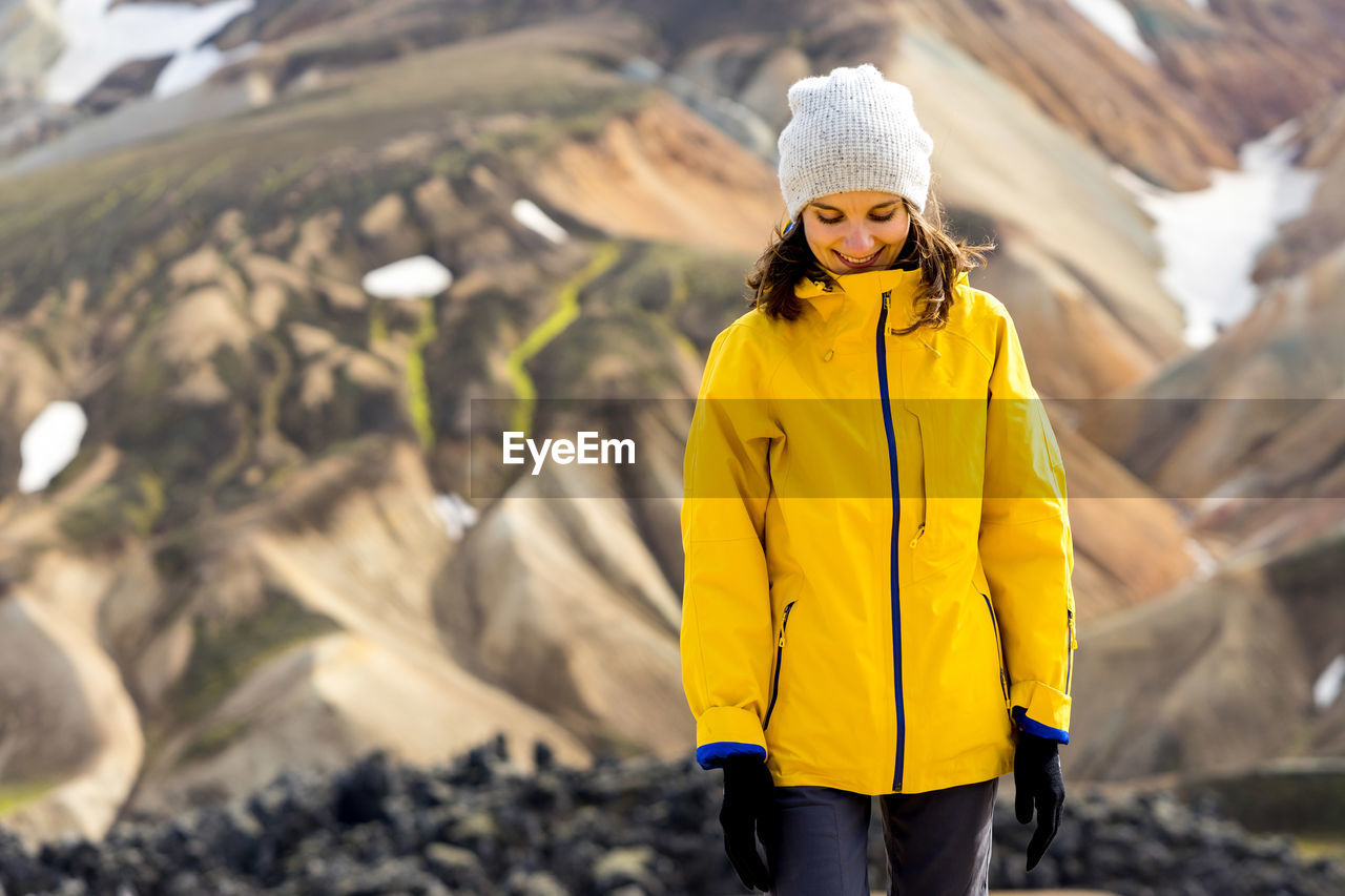 Young woman hiker walking around iceland's highlands and mossy hills