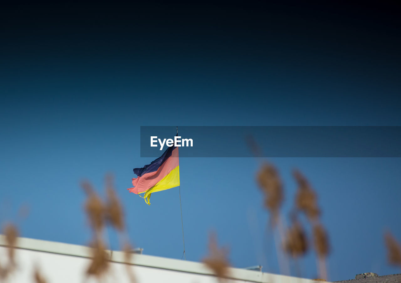 LOW ANGLE VIEW OF FLAGS FLAG AGAINST CLEAR BLUE SKY