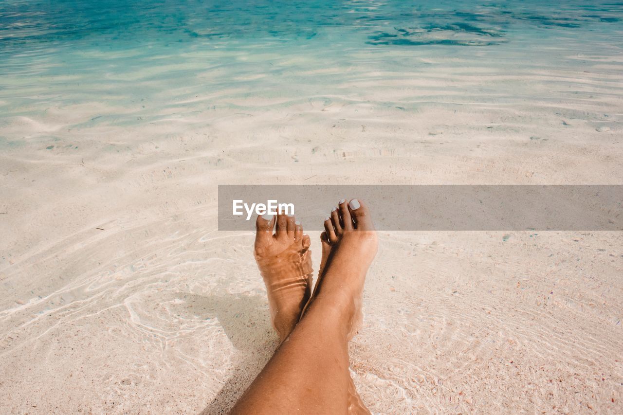 Low section of woman relaxing in sea