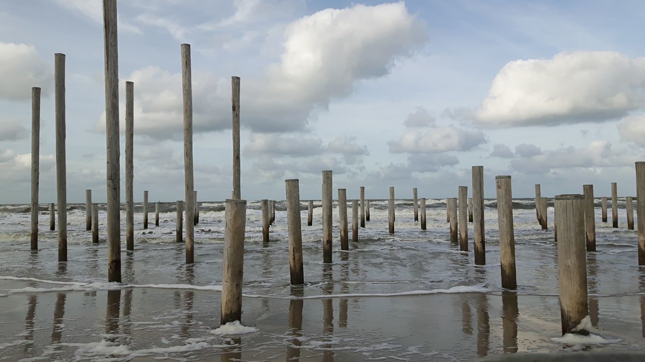 PANORAMIC VIEW OF WOODEN POSTS IN SEA