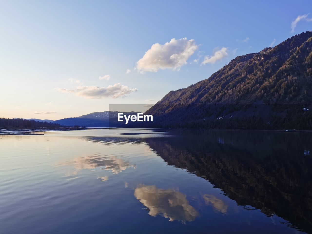 Scenic view of lake by mountains against sky