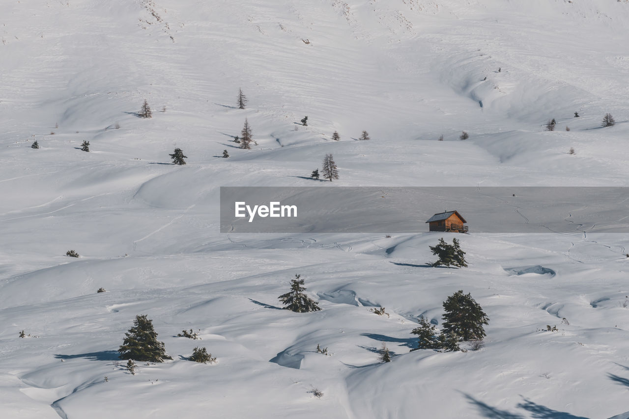 A picturesque view of a remote house in the snowcapped french alps mountains