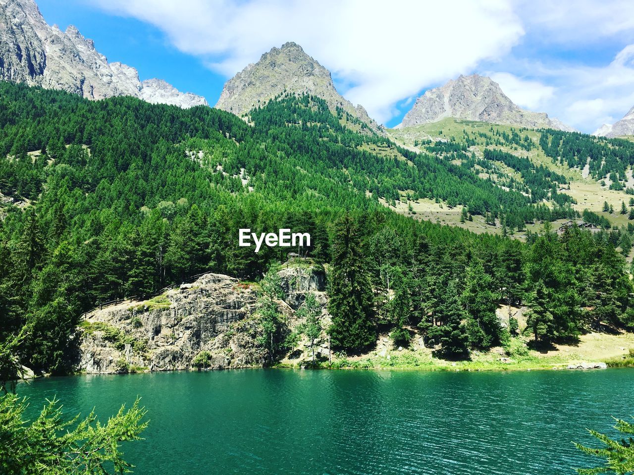 Scenic view of lake by mountains against sky