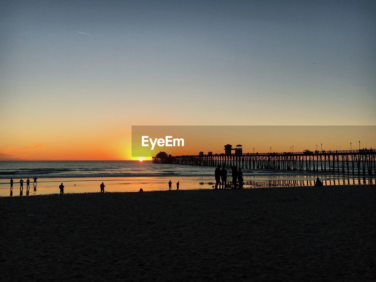 SCENIC VIEW OF BEACH AGAINST CLEAR SKY DURING SUNSET