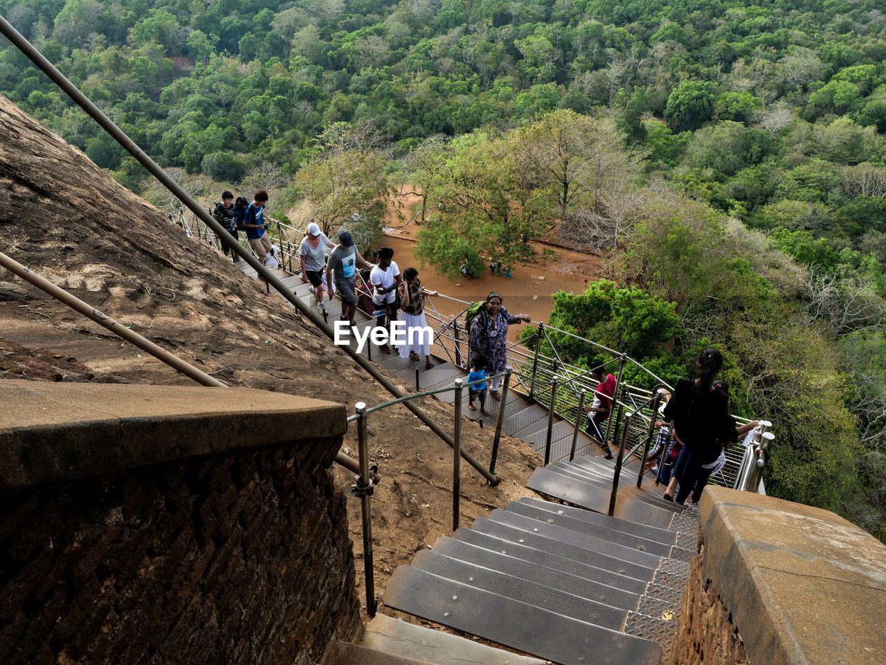 HIGH ANGLE VIEW OF PEOPLE WALKING ON STAIRCASE