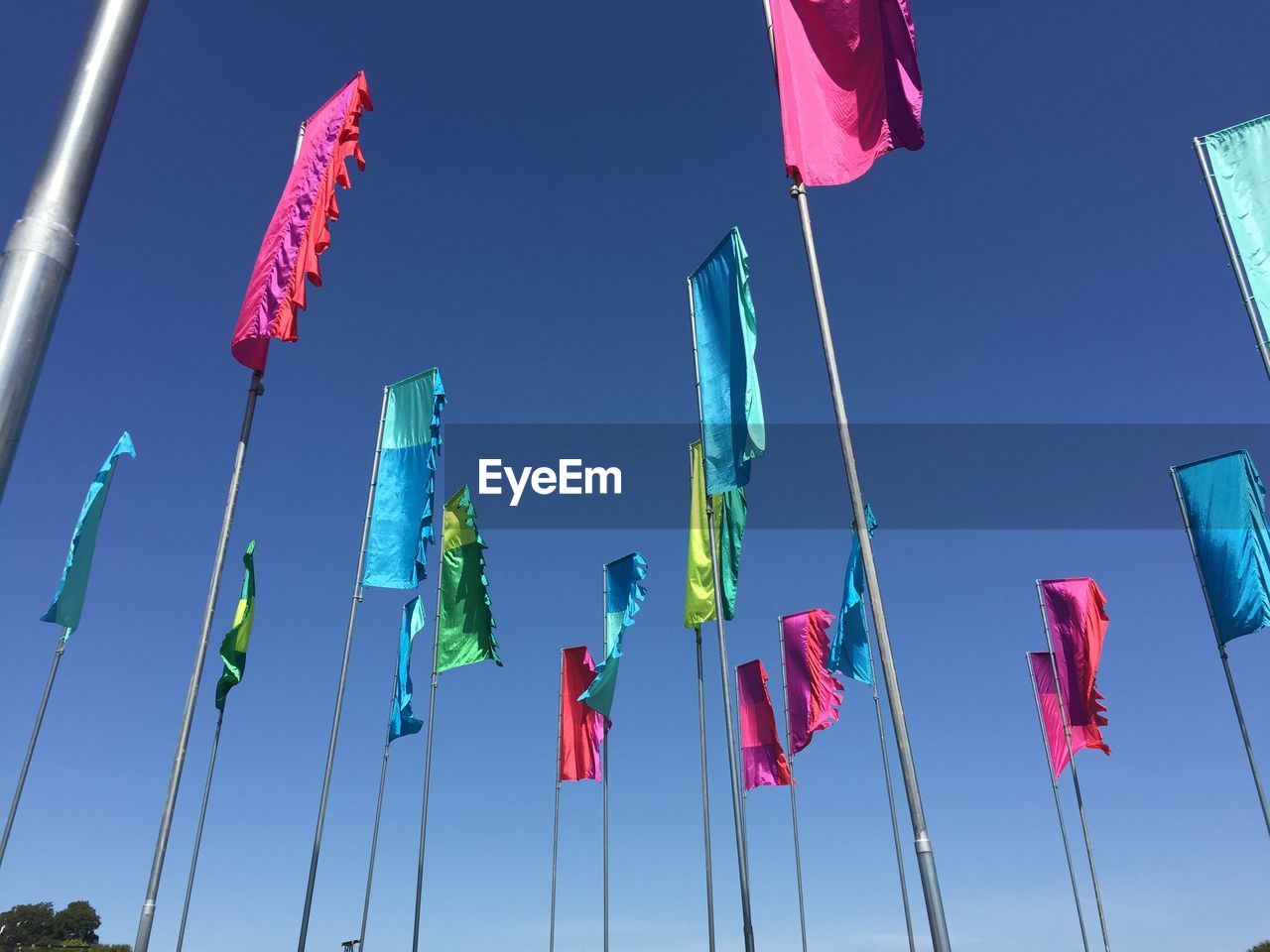 Low angle view of colorful flags against sky