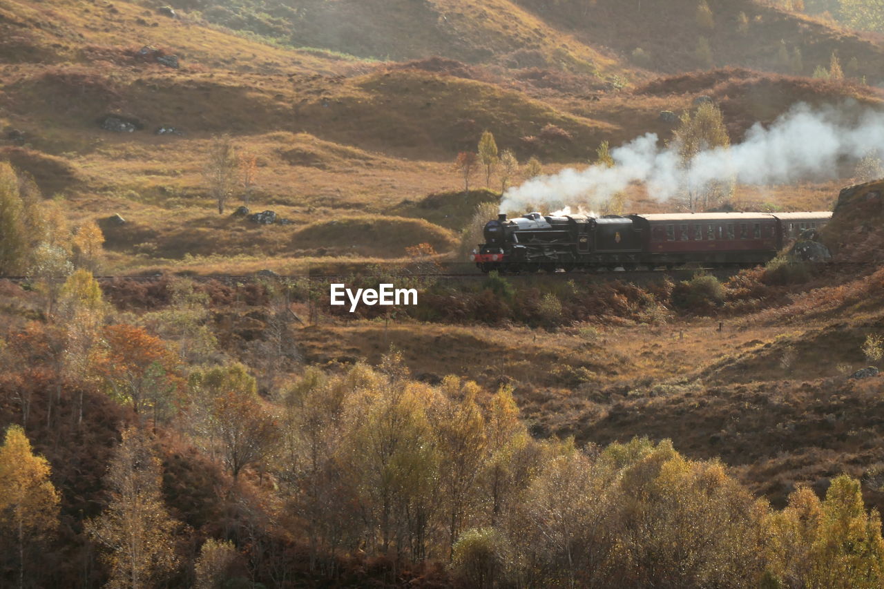 Steam train passing through scottish countryside 