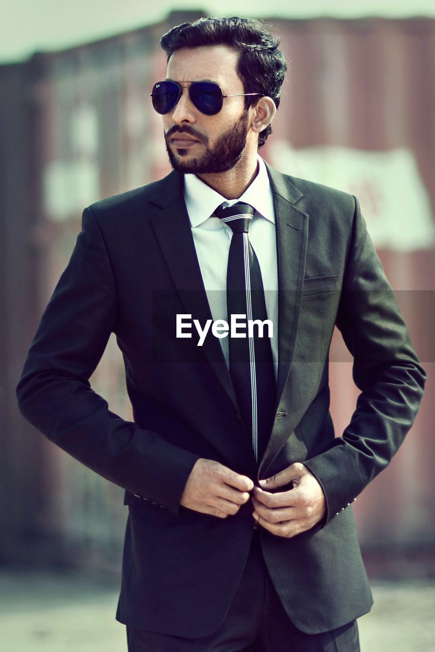 men, business, fashion, adult, sunglasses, formal wear, one person, businessman, glasses, city, tuxedo, blazer, corporate business, architecture, standing, business finance and industry, city life, elegance, young adult, cool attitude, eyewear, clothing, portrait, suave, occupation, vision care, success, lifestyles, spring, professional occupation, wealth, facial hair, looking, arts culture and entertainment, outerwear, beard, front view, outdoors, tie, happiness