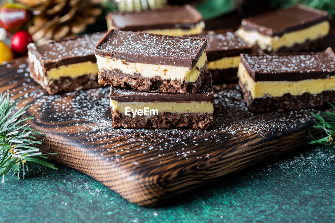 Close up of delicious nanaimo bars sprinkled with powdered sugar.