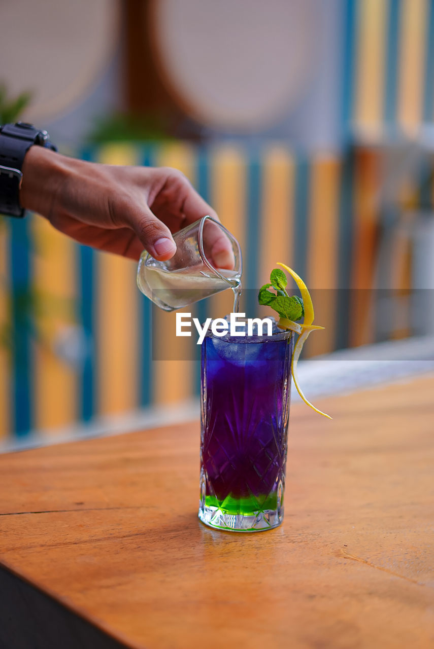 cropped hand of man holding drink