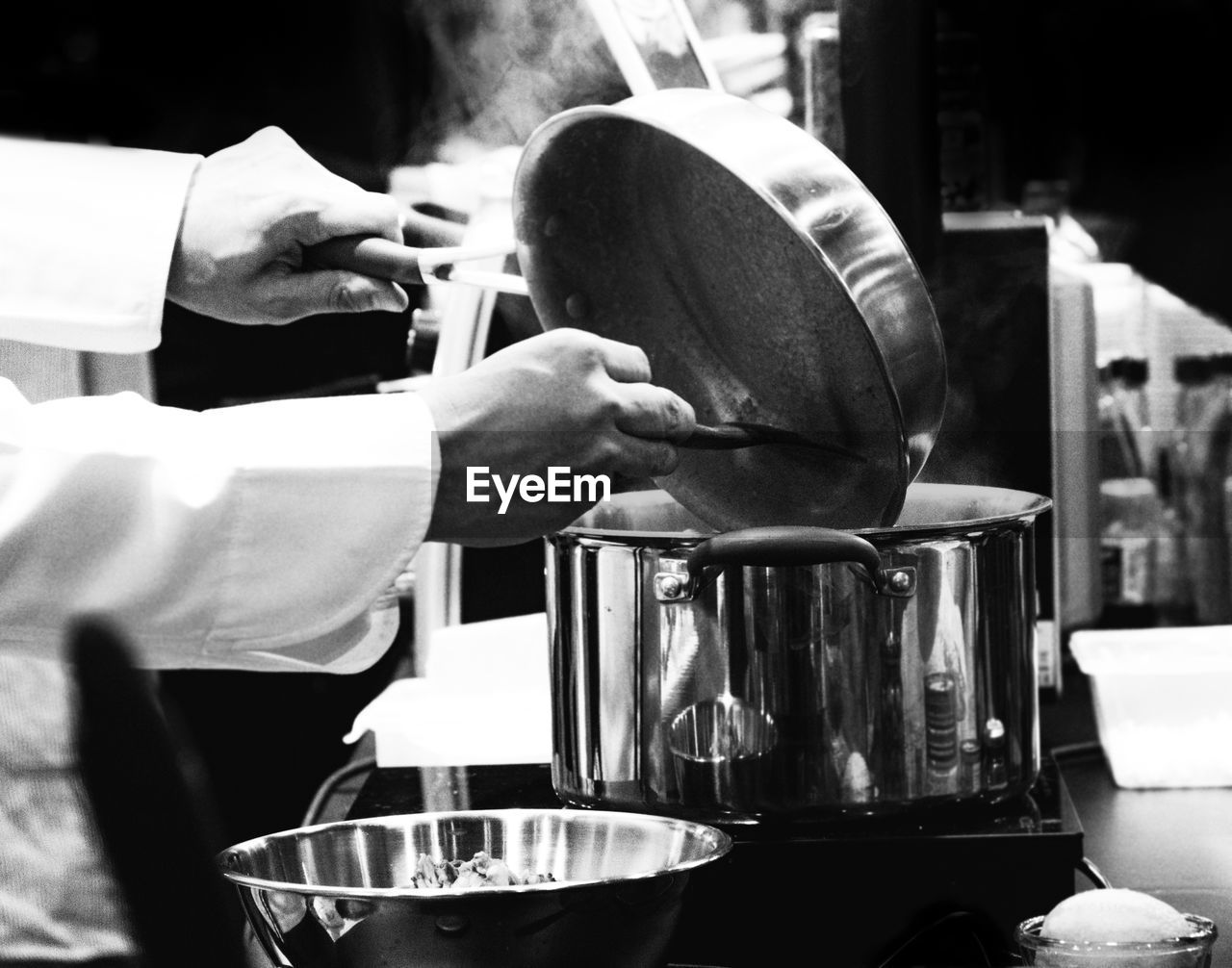 MIDSECTION OF MAN PREPARING FOOD AT KITCHEN