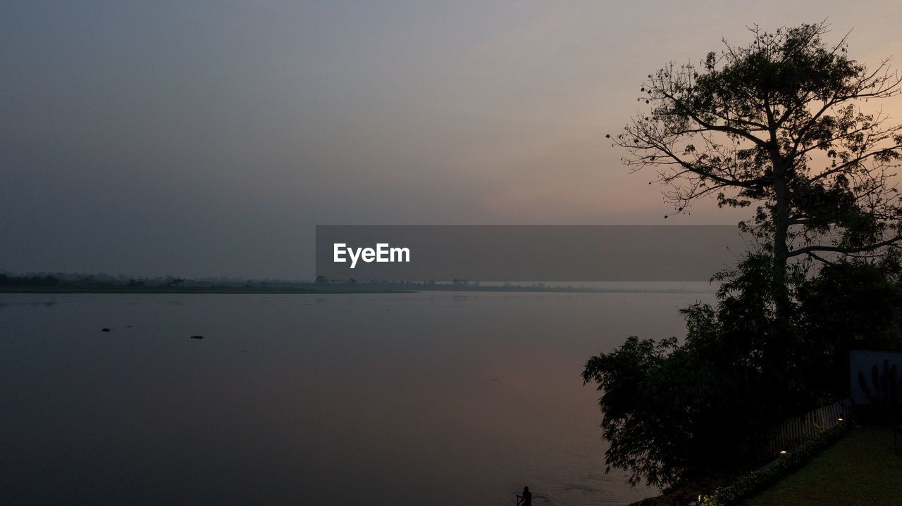 SCENIC VIEW OF LAKE AGAINST SKY AT SUNSET