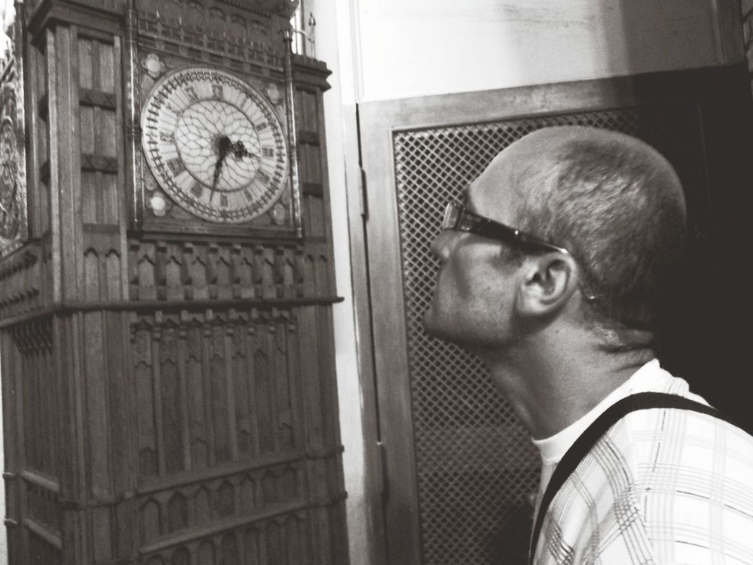 Mature man looking at grandfather clock