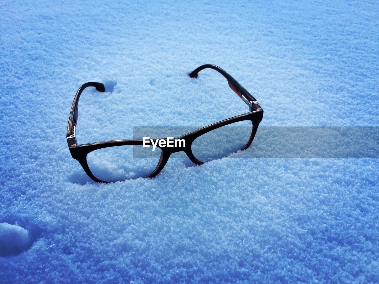 High angle view of eyeglasses on snow