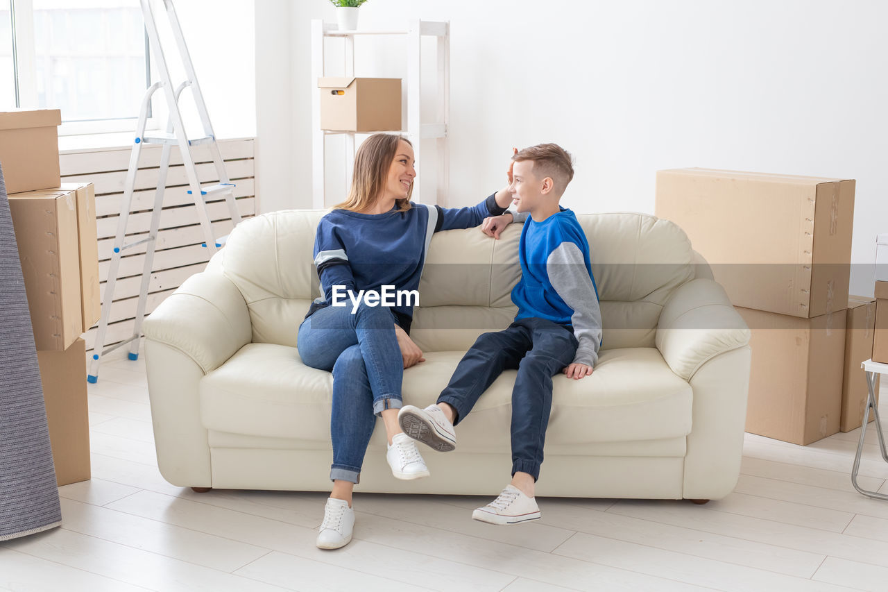 WOMEN SITTING ON SOFA AT HOME