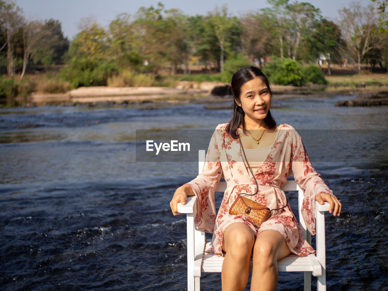 A woman sitting in a chair in the middle of the river