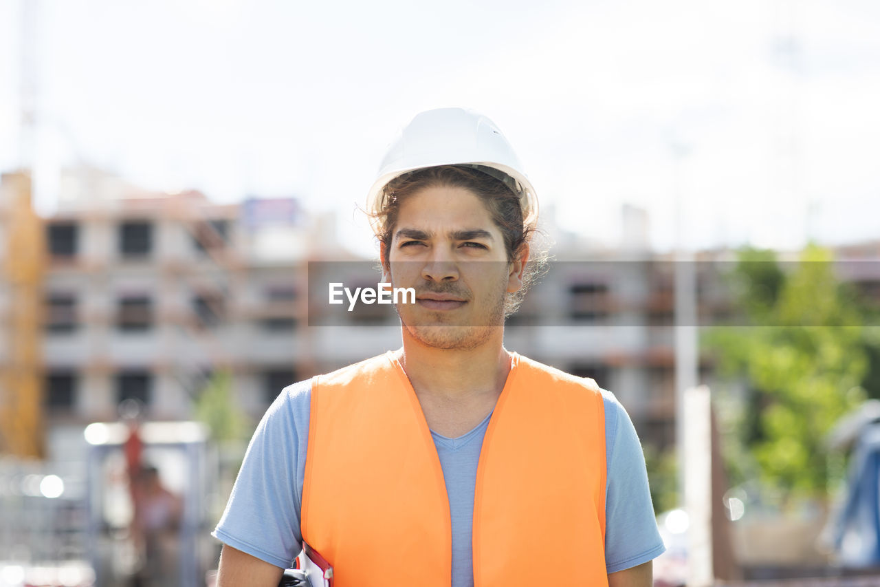 Young construction engineer with helmet working outside