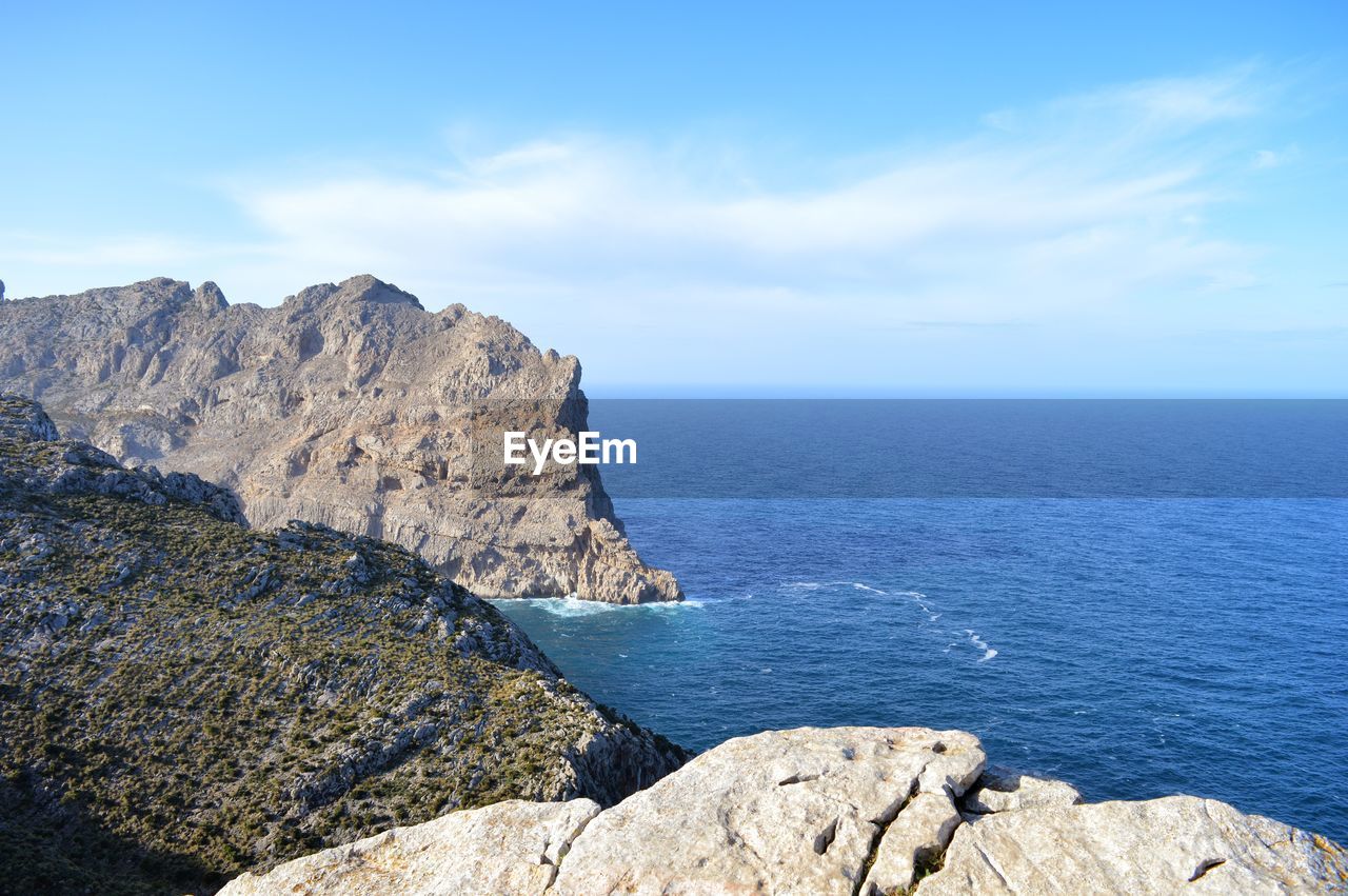 SCENIC VIEW OF SEA BY ROCKS AGAINST SKY