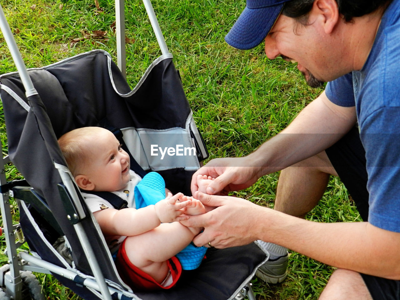 High angle view of man playing with baby in carriage