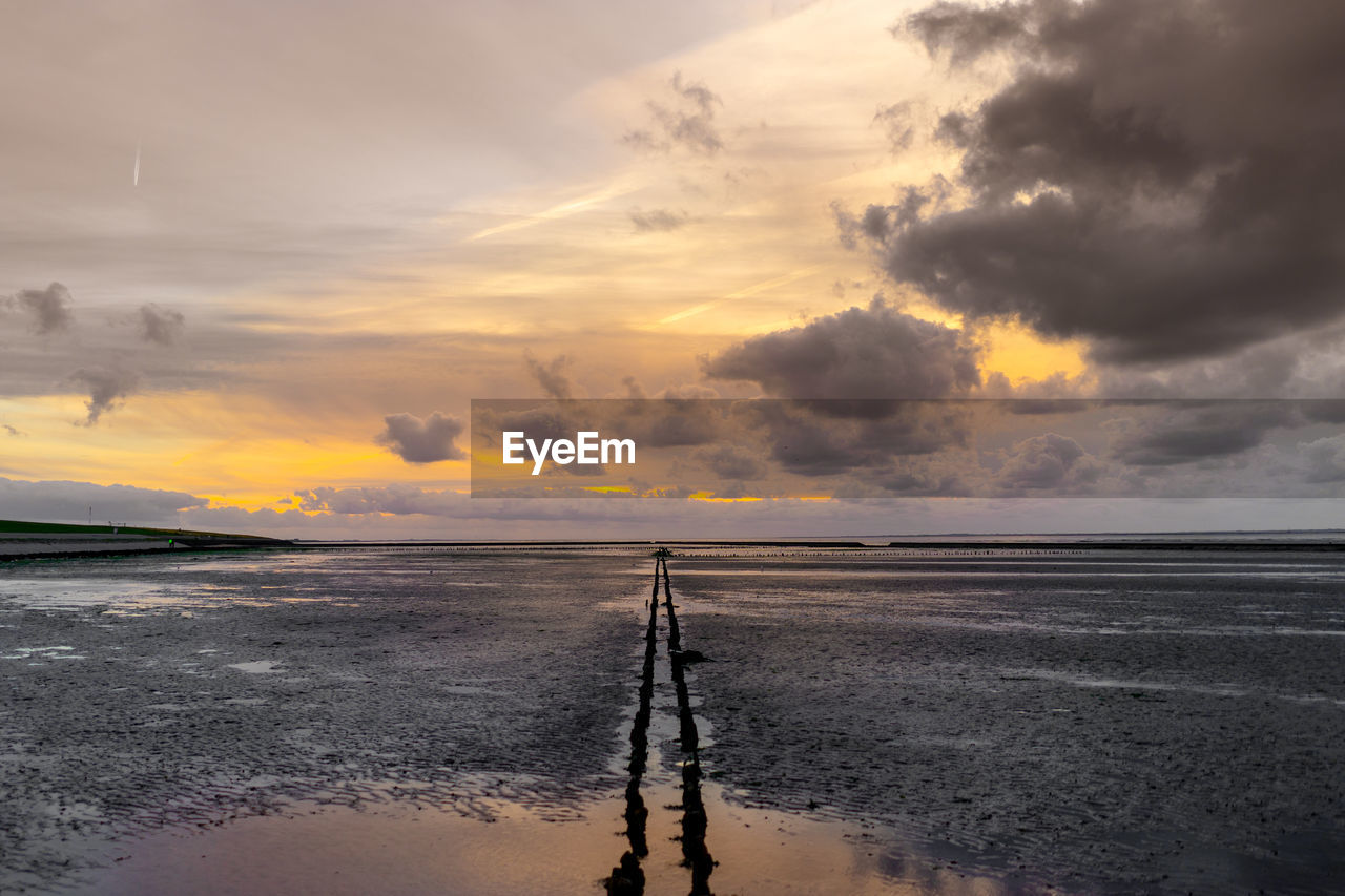 SCENIC VIEW OF BEACH AGAINST SKY AT SUNSET