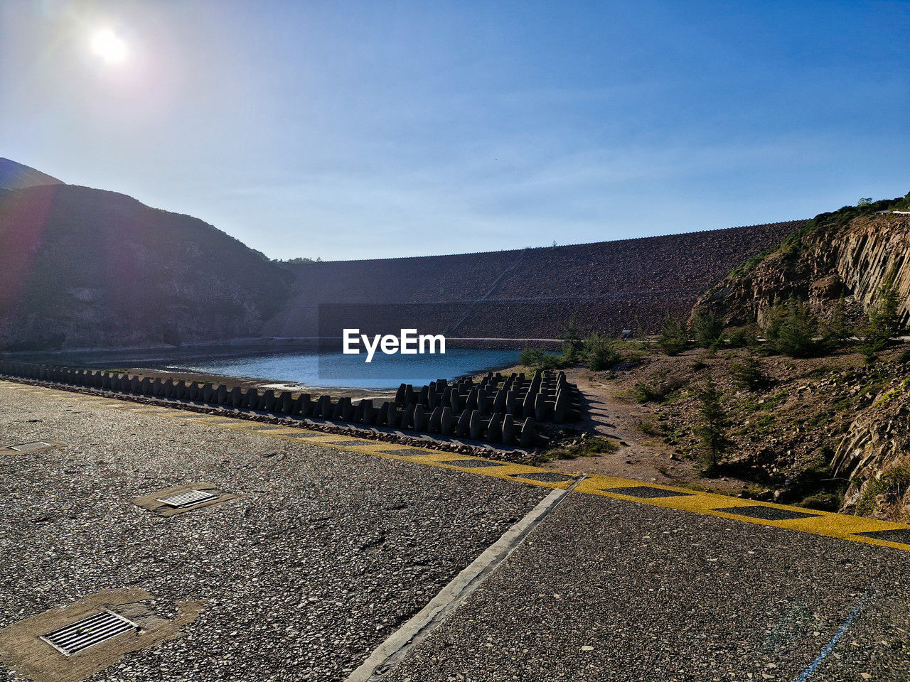 sky, nature, road, mountain, environment, sea, scenics - nature, landscape, transportation, no people, coast, beauty in nature, water, horizon, land, sunlight, outdoors, travel, tranquility, travel destinations, day, non-urban scene, sun, tranquil scene, rock