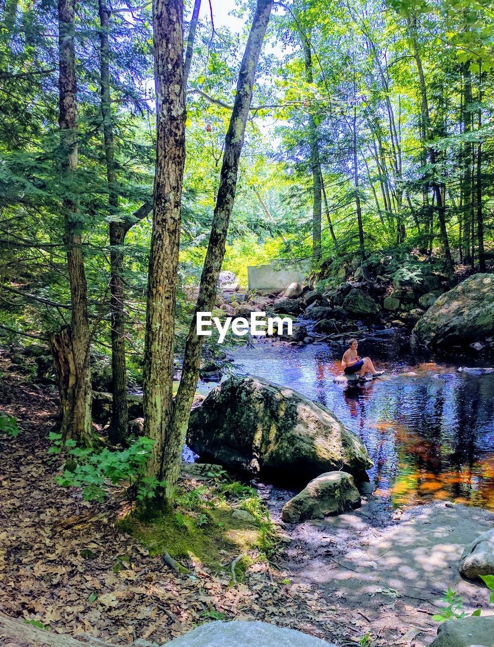 Mid distant view of woman sitting in lake