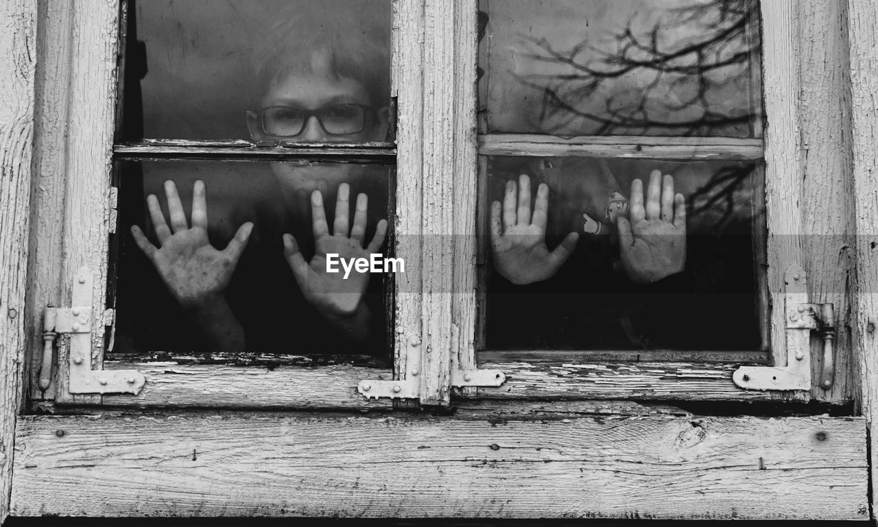 Portrait of boys looking through window