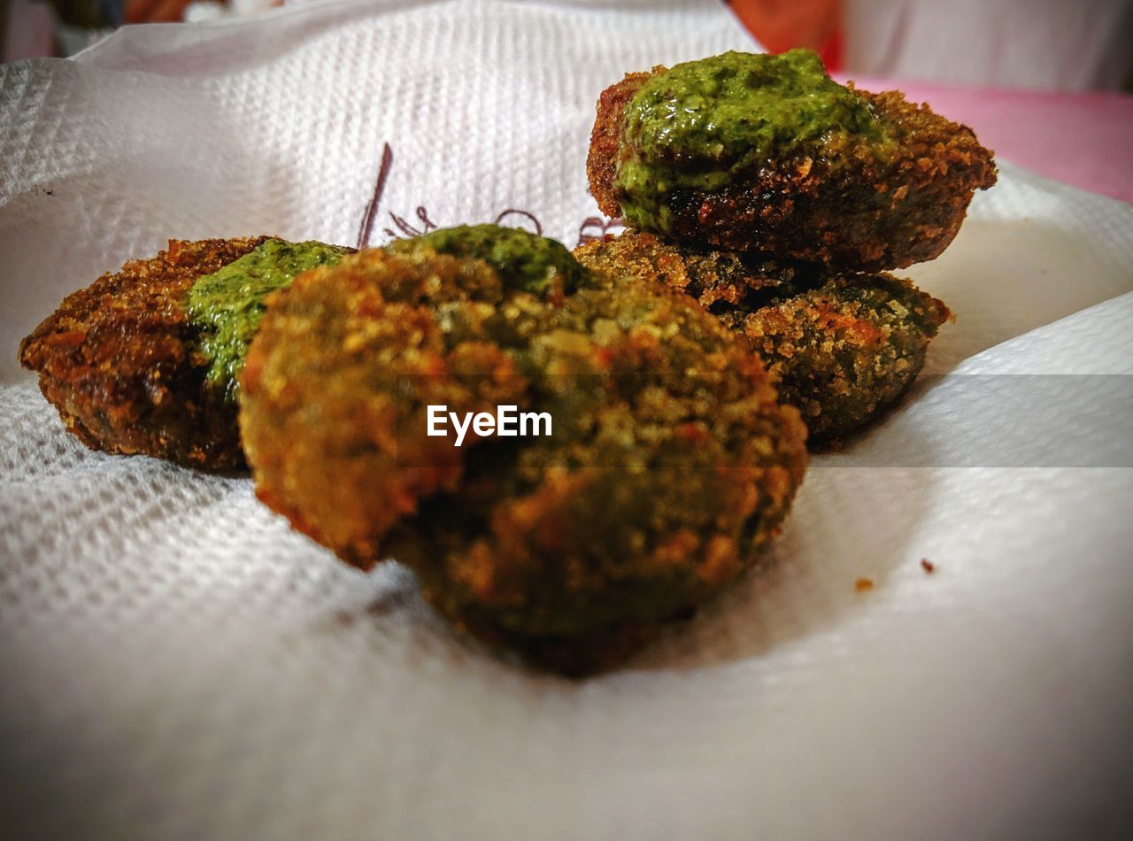 Close-up of patties with chutney on tissue paper