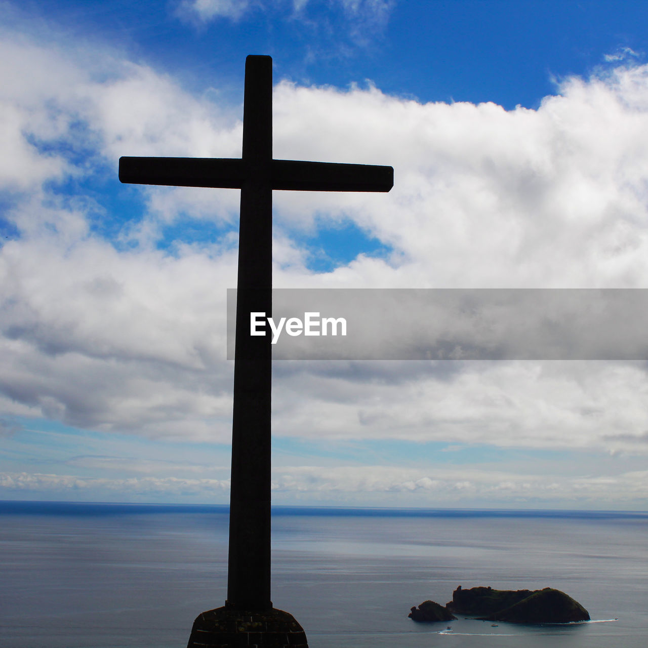 CROSS ON SHORE AGAINST SKY