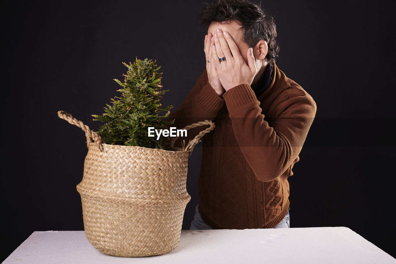 one person, flowerpot, adult, men, emotional stress, studio shot, indoors, person, black background, plant, overworked, head in hands, sadness, business, depression - sadness, negative emotion, basket, frustration, emotion, business finance and industry, nature, houseplant, hand, despair, worried, container, occupation, businessman
