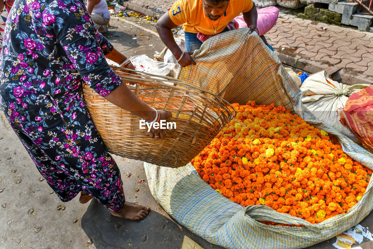 HIGH ANGLE VIEW OF MAN WORKING IN BASKET AT MARKET