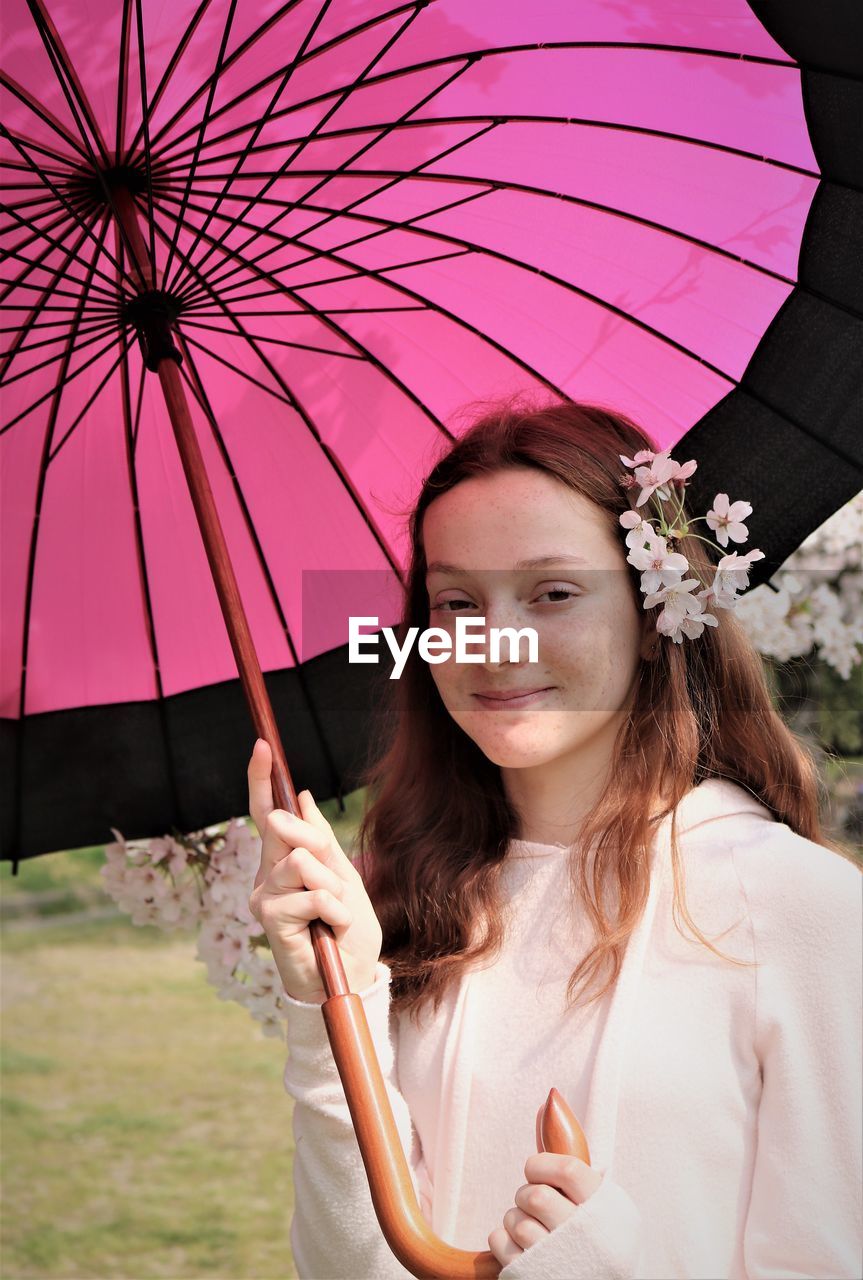 Portrait of smiling girl holding umbrella