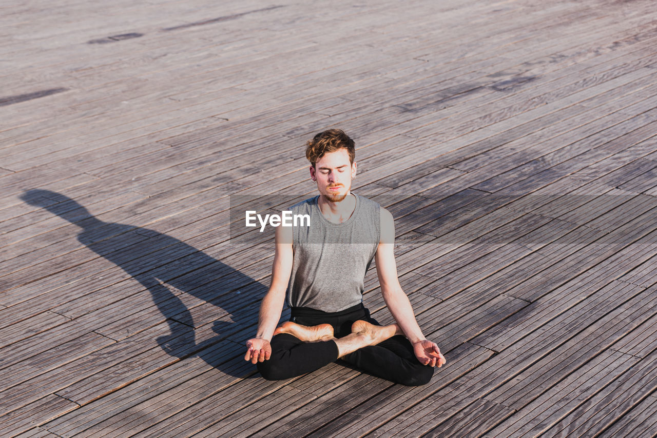 Portrait of man sitting on wooden floor