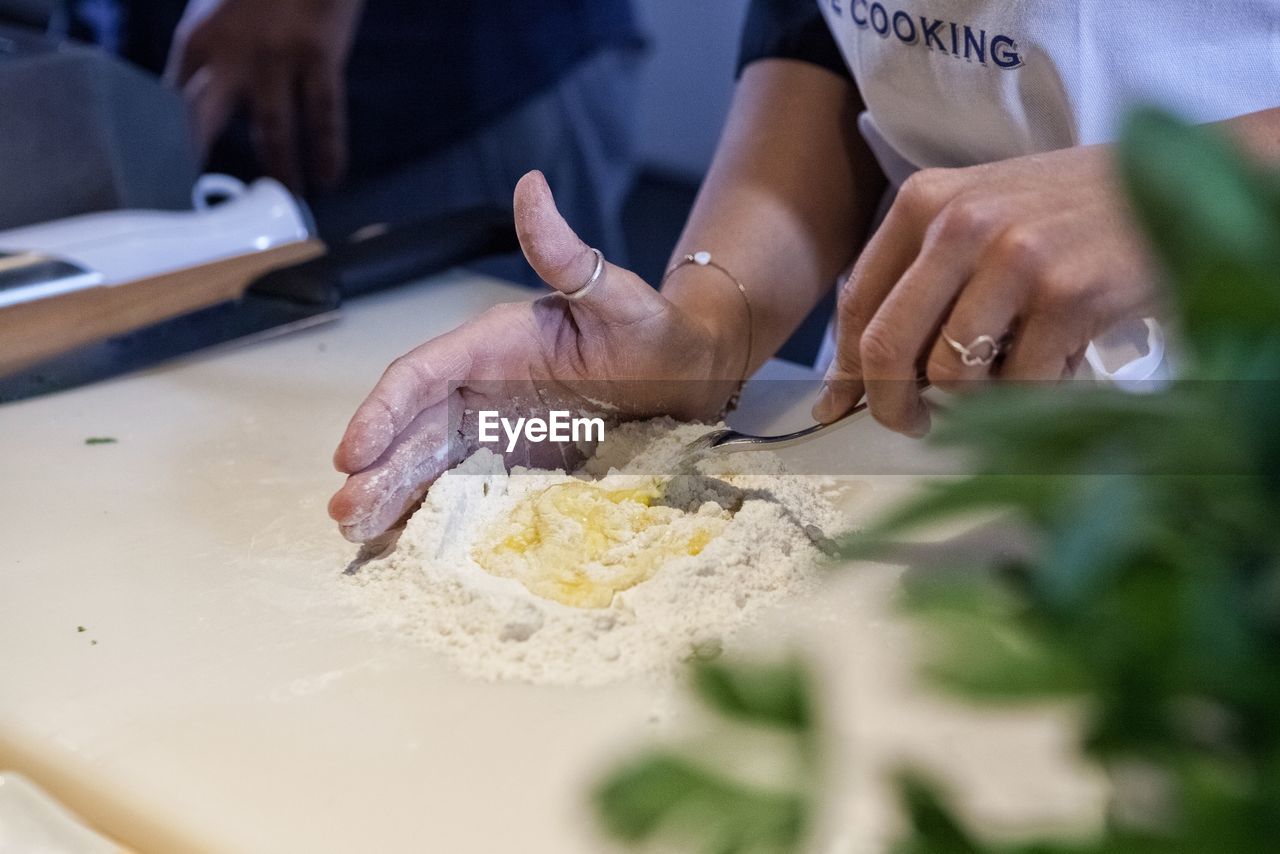 Close-up of woman preparing food on table