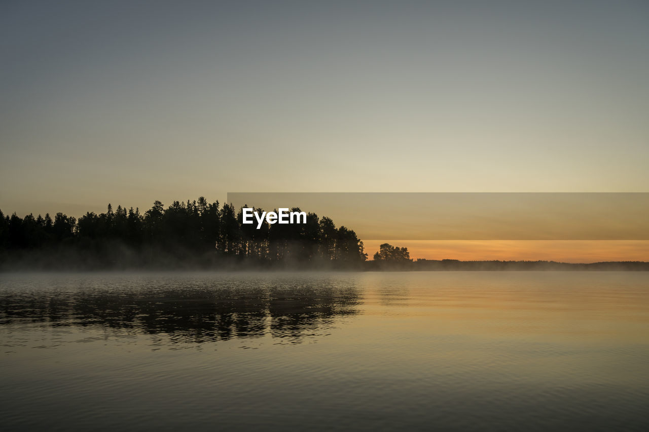 Scenic view of lake against sky during sunrise