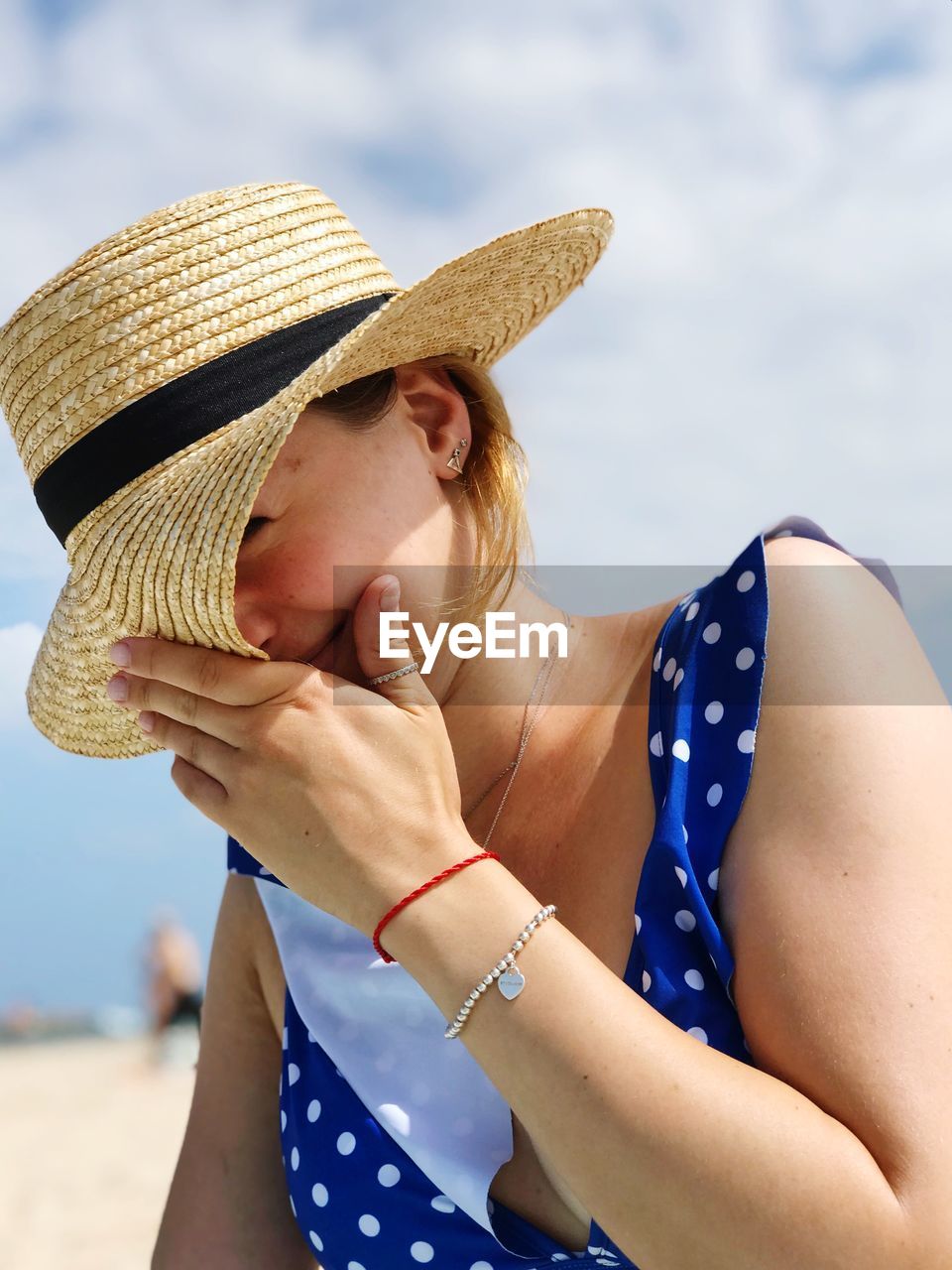 Smiling woman wearing hat against sky