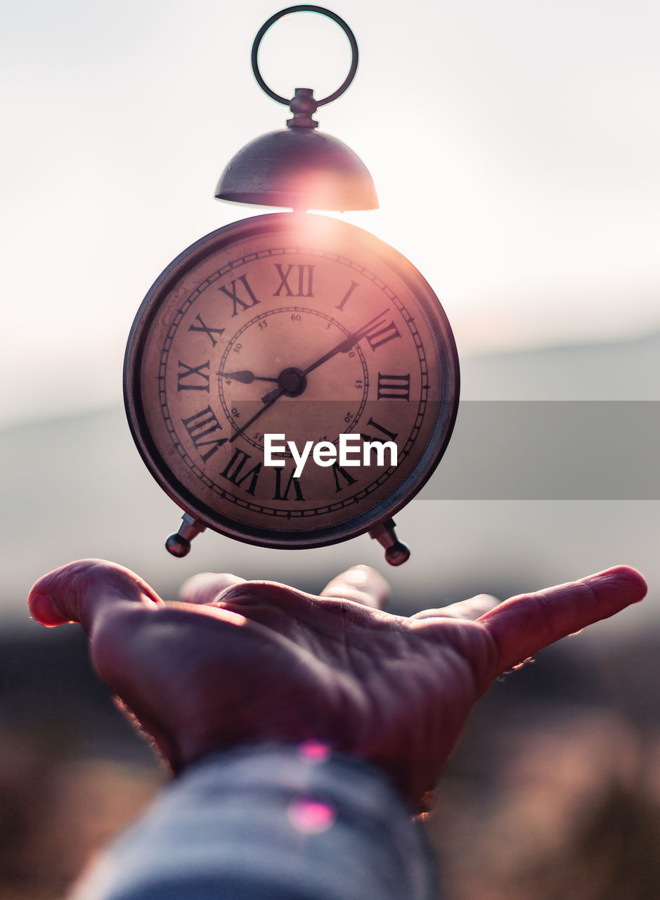 Close-up of hand catching alarm clock