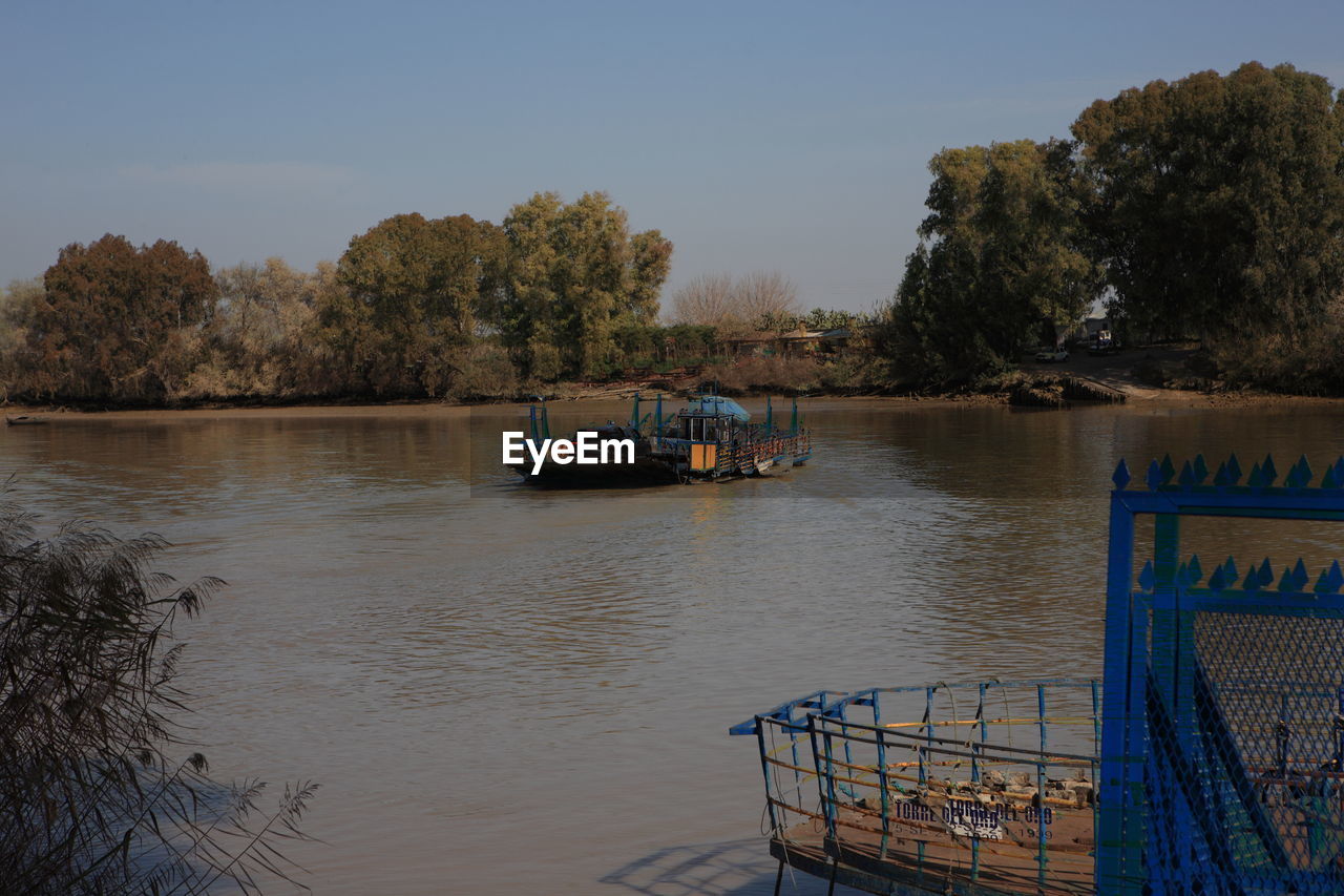 Boats sailing in river against sky