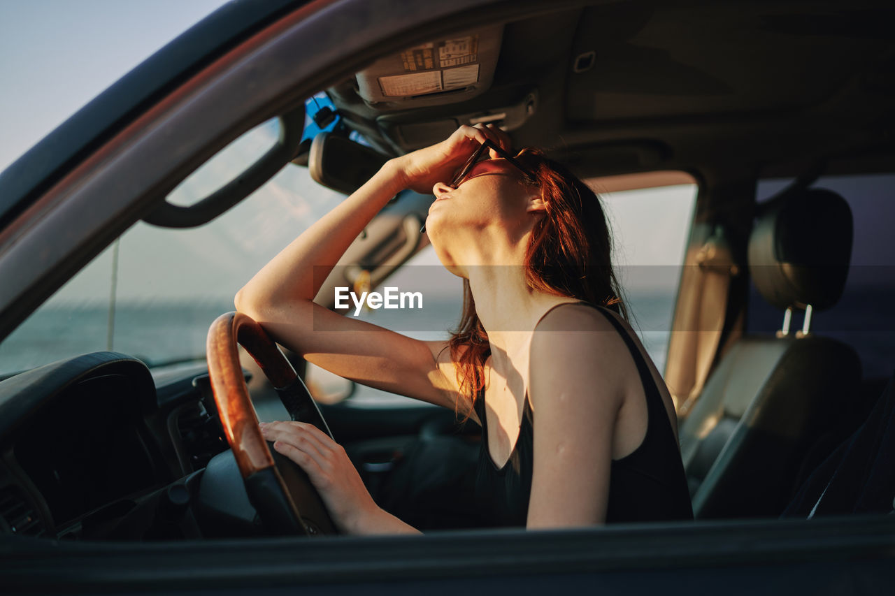 SIDE VIEW OF WOMAN IN CAR