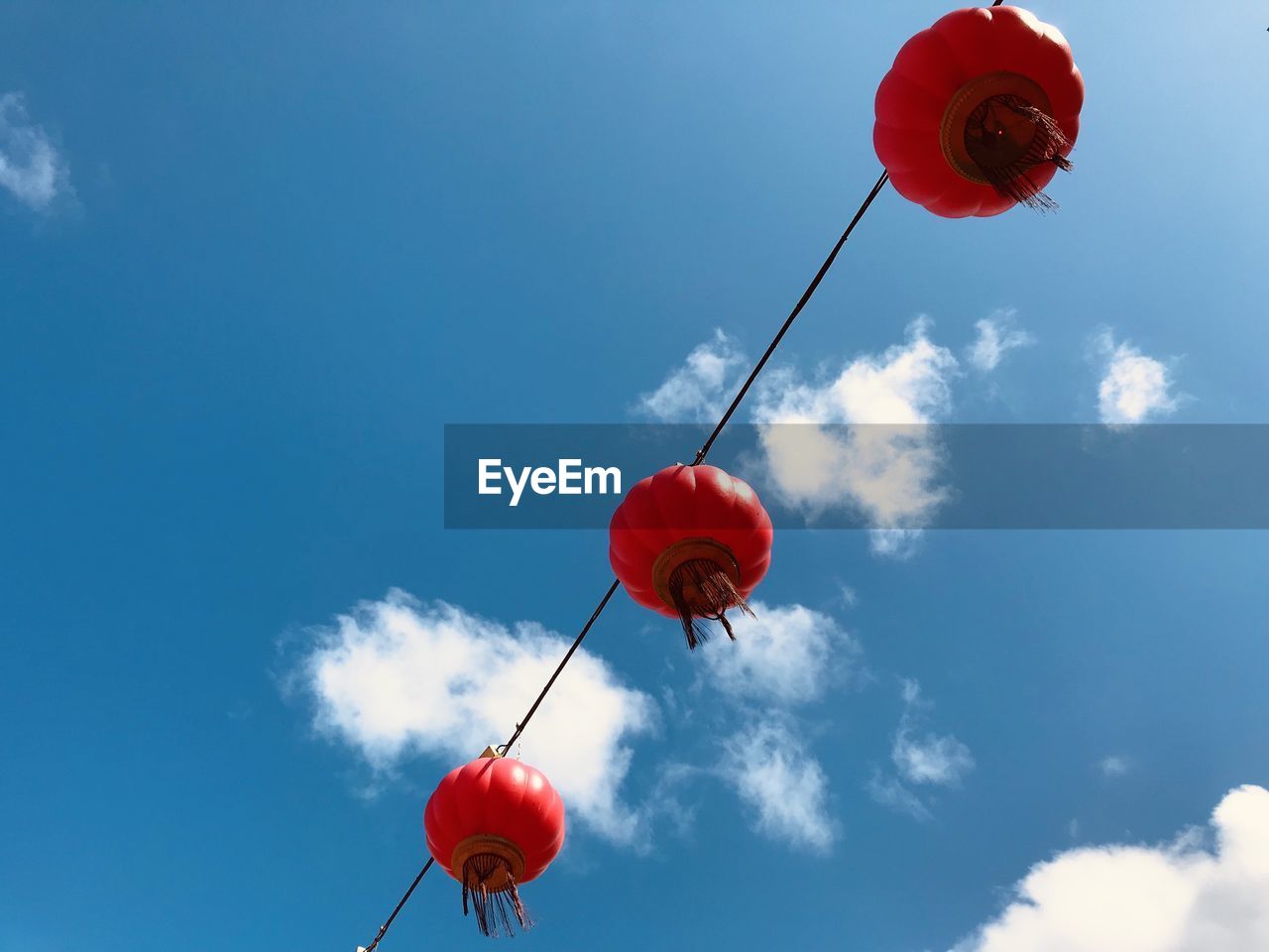 Low angle view of red balloons against sky