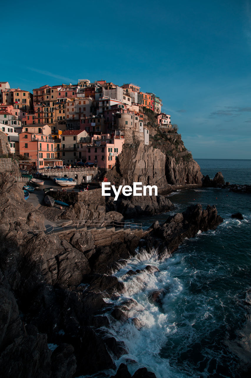 Scenic view of sea by buildings against sky