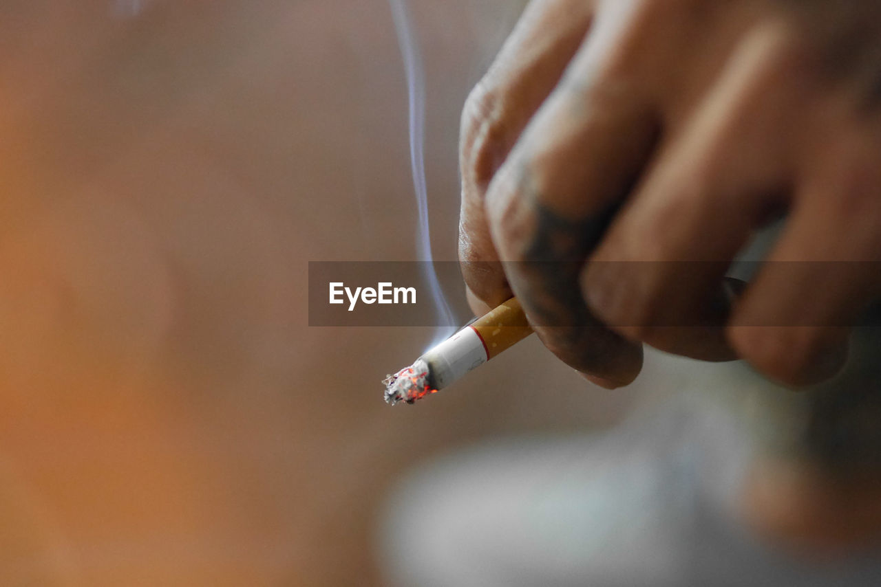 Cropped hand of person holding cigarette