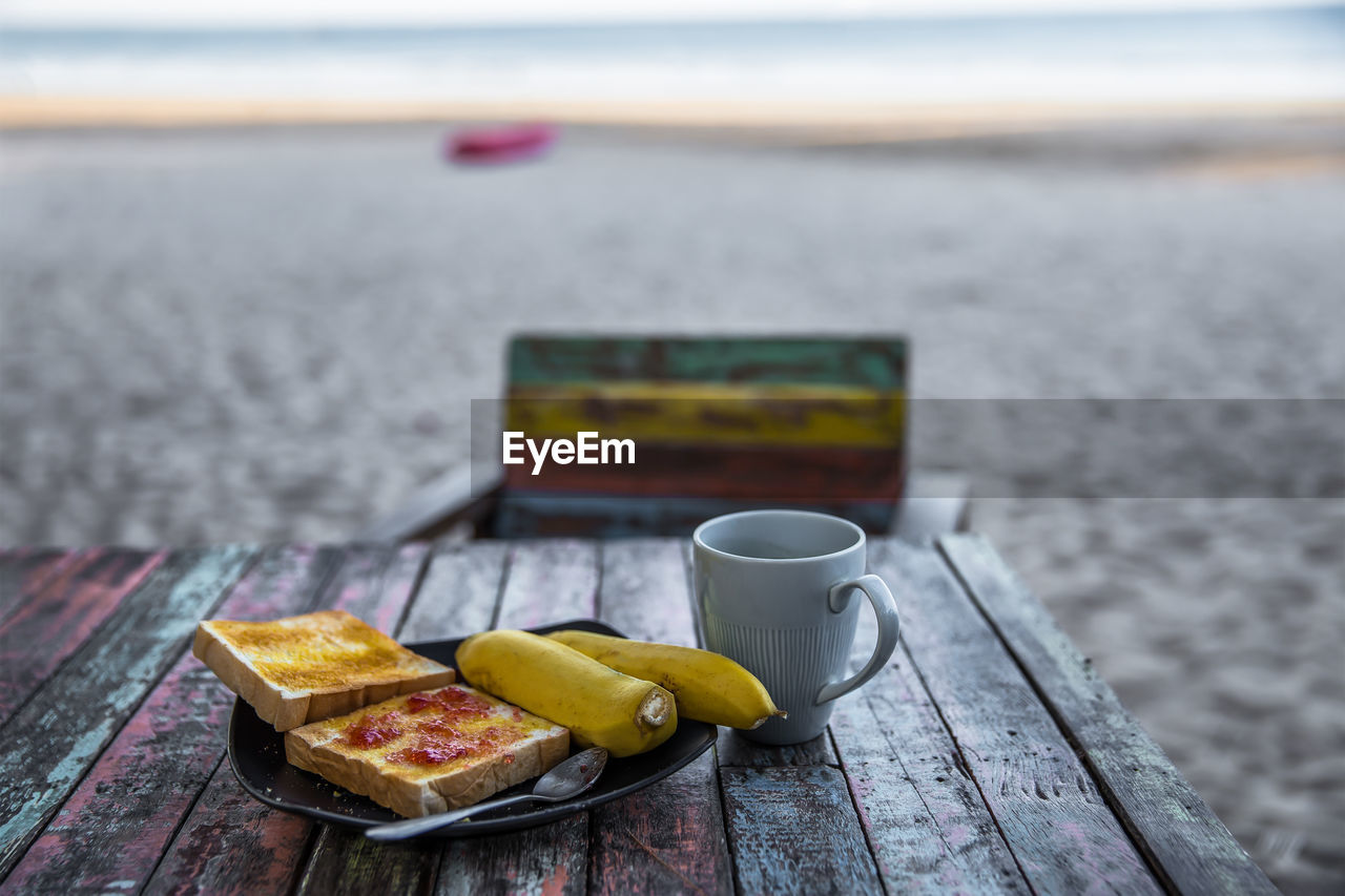 CLOSE-UP OF BREAKFAST ON TABLE AT BEACH