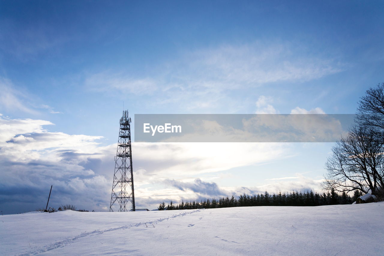 ELECTRICITY PYLON ON SNOW COVERED FIELD