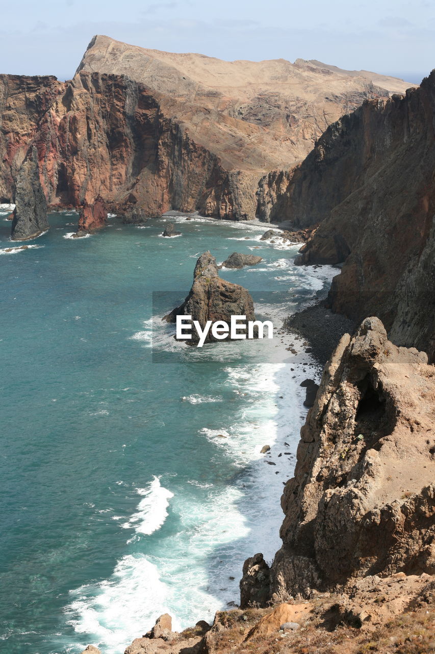 Scenic view of sea and mountains against sky