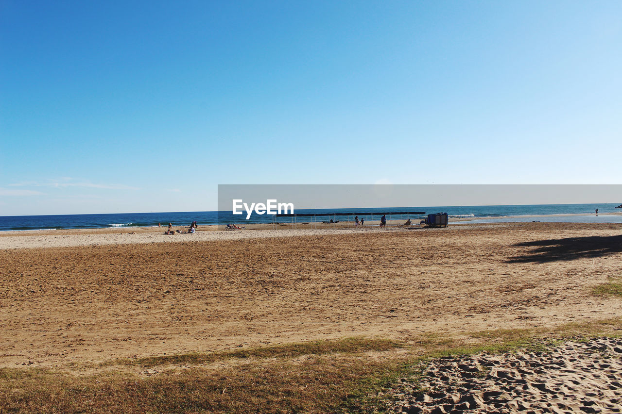 Scenic view of beach against clear blue sky