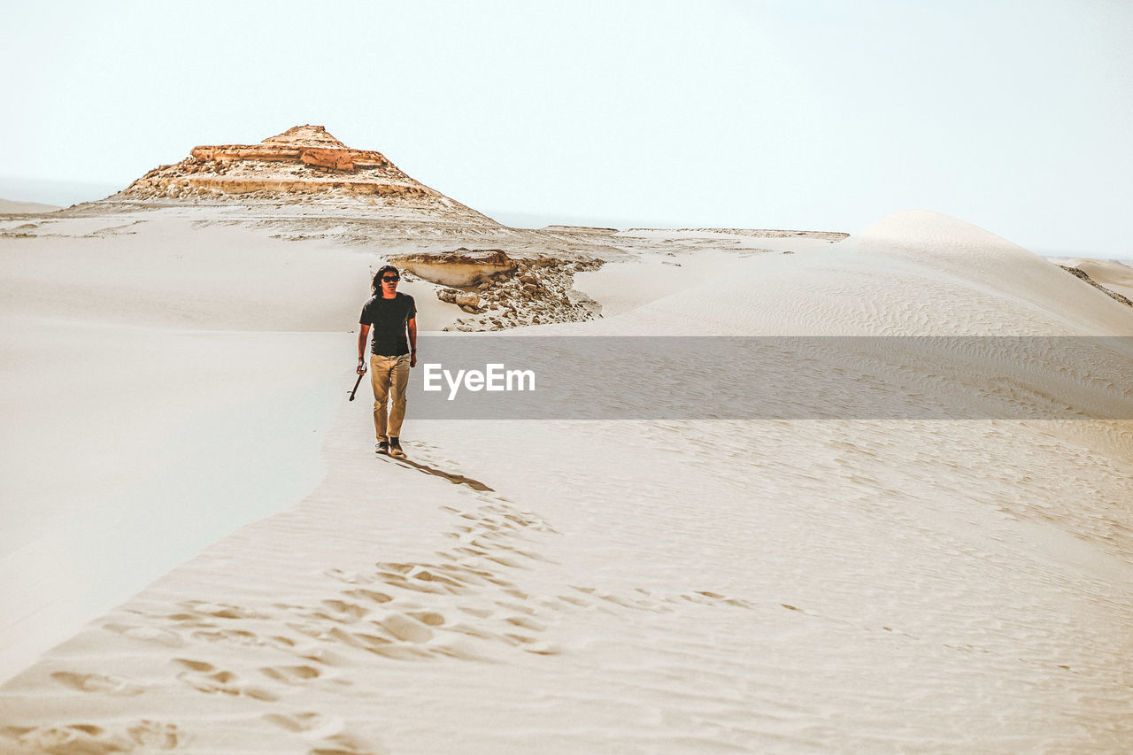 Rear view of man walking in desert