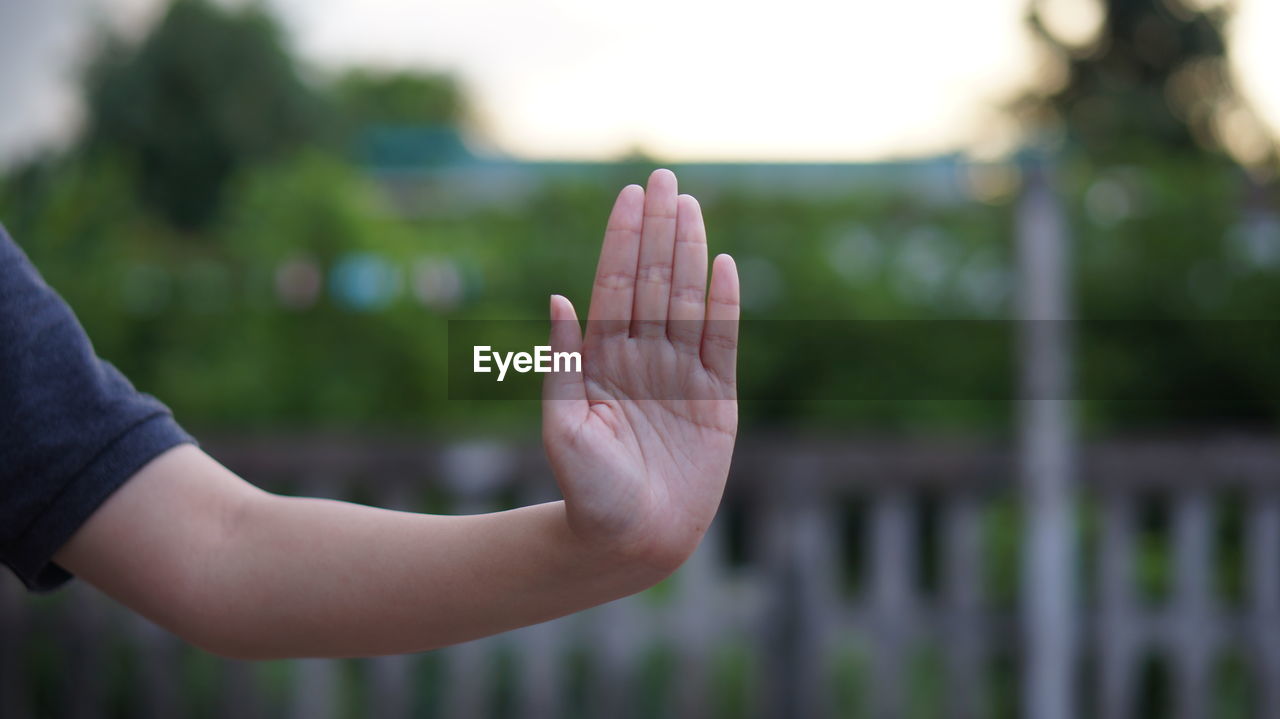 Close-up of females hand showing stop sign