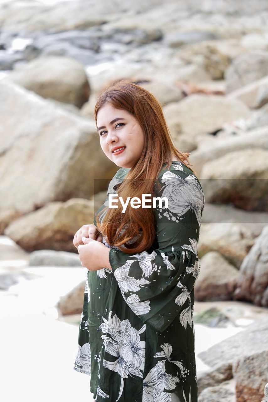 Portrait of young woman standing at beach